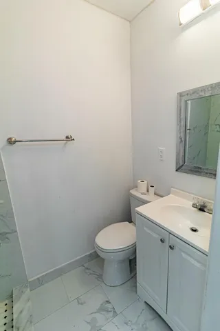 a bathroom with a toilet a sink and mirror