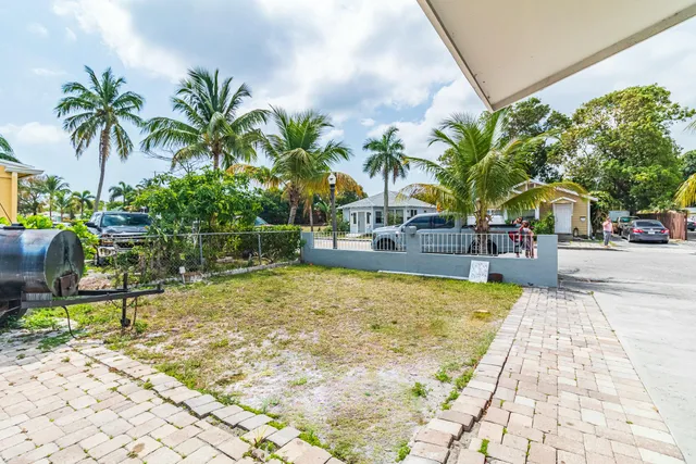 a palm tree sitting in front of a house with a patio