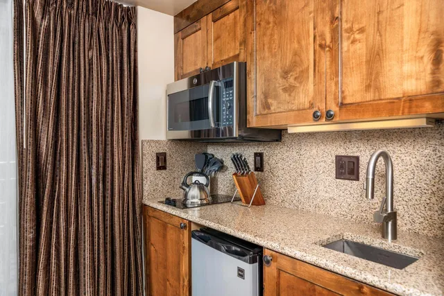 a kitchen with stainless steel appliances granite countertop a sink and a microwave