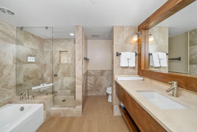 a bathroom with a bathtub shower sink and mirror