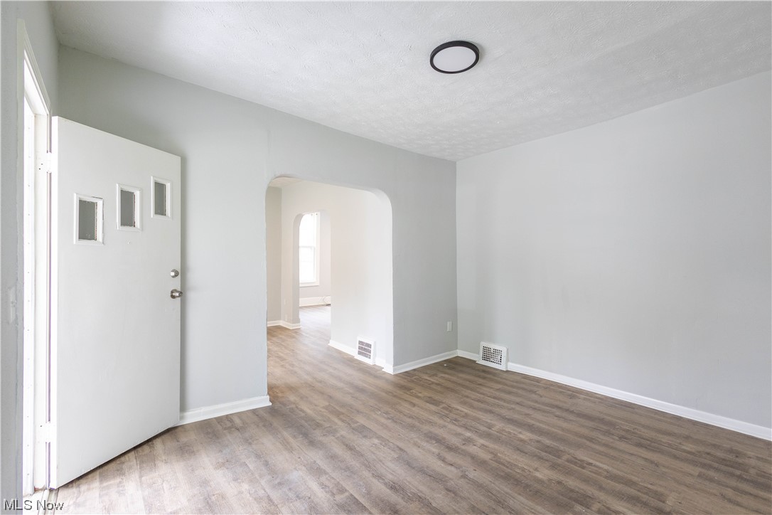 11838 Triskett Road Cleveland, OH 44111 - Photo 1 of 20 Empty room with light hardwood floors and a textured ceiling