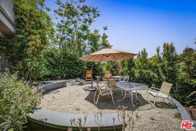 a view of backyard with seating space and trees