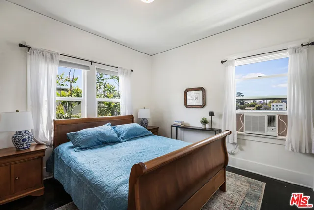 a bed sitting in a bedroom next to a window