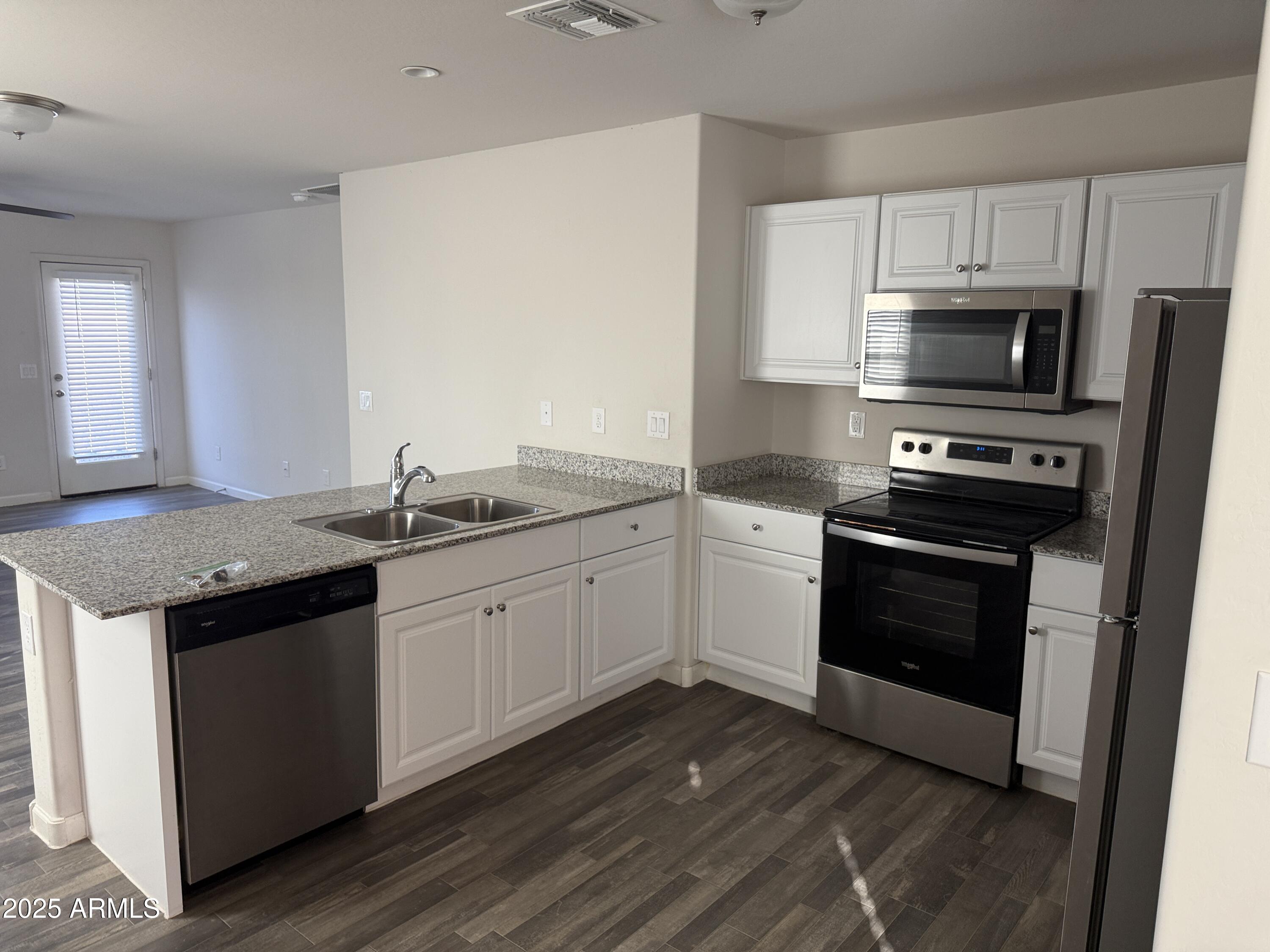 1098 South 11th Street Coolidge, AZ 85128 - Photo 7 of 20 a kitchen with granite countertop stainless steel appliances a sink cabinets and a counter space