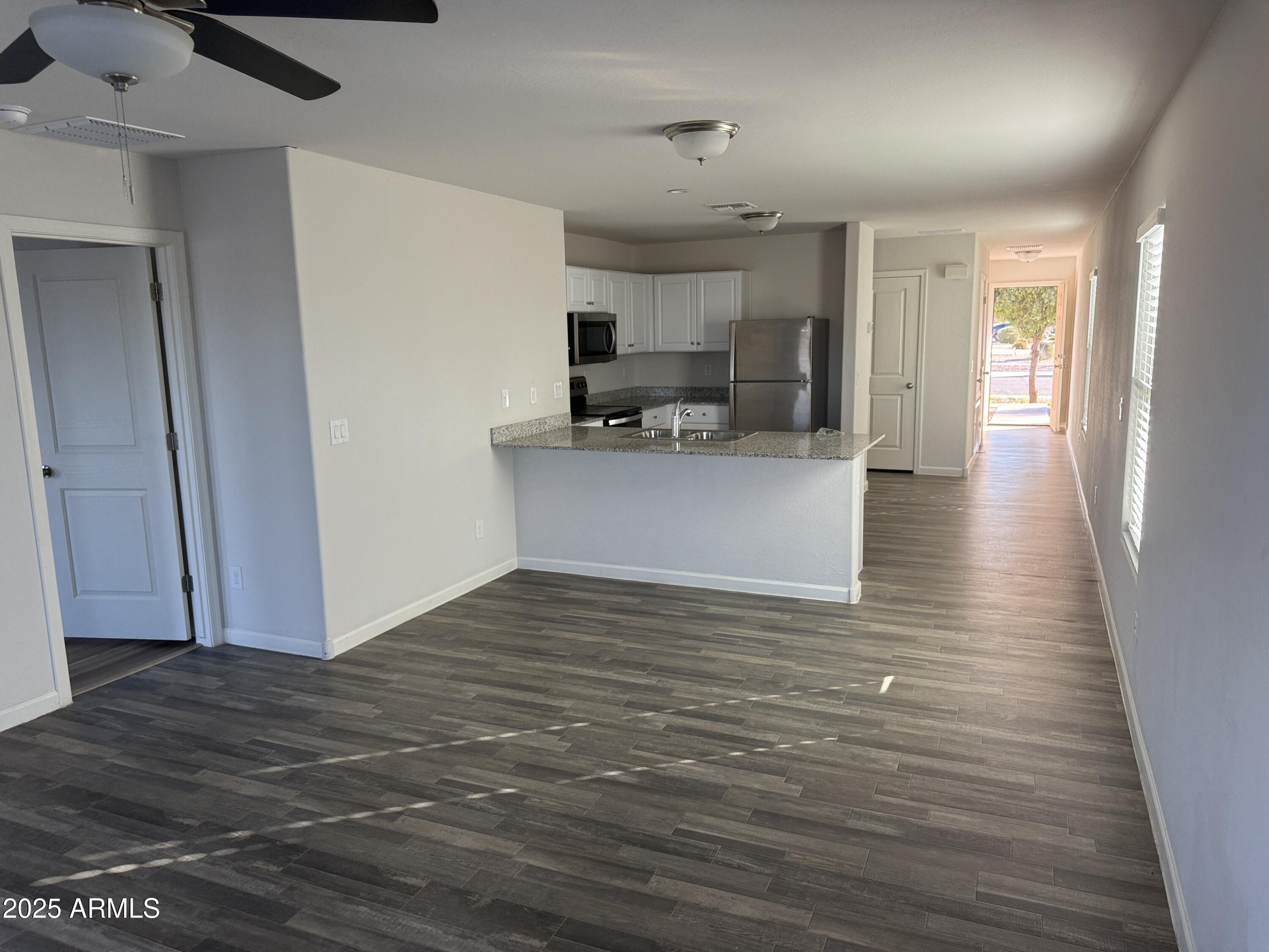 1098 South 11th Street Coolidge, AZ 85128 - Photo 8 of 20 a view of kitchen and empty room with wooden floor