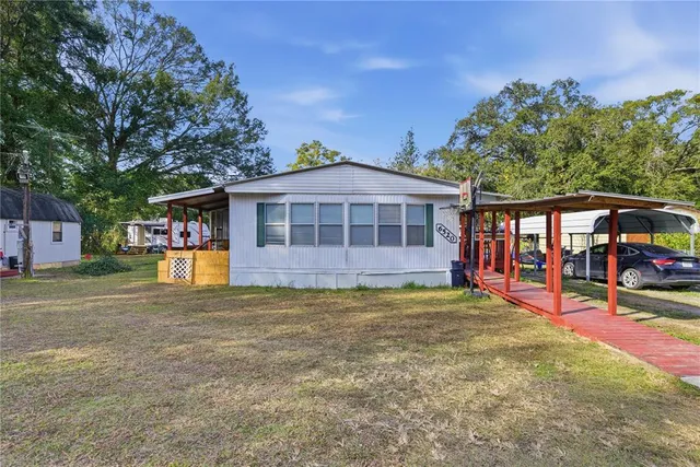 a view of a house with backyard and sitting area
