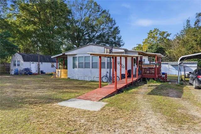 a view of a house with backyard and sitting area