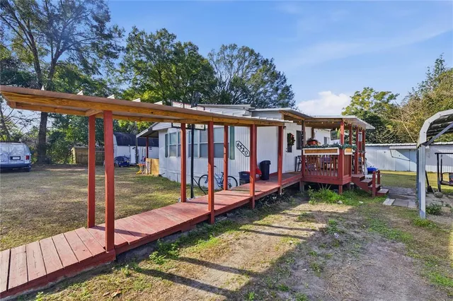 a view of a backyard with a large tree and a wooden fence