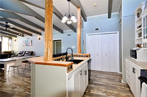 a kitchen that has a lot of white cabinets and stainless steel appliances