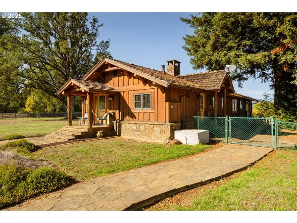 a view of a house with backyard and sitting area