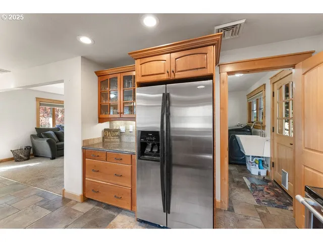 a kitchen with stainless steel appliances kitchen island granite countertop a refrigerator and cabinets