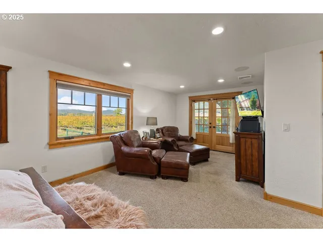 a living room with furniture a flat screen tv and a floor to ceiling window