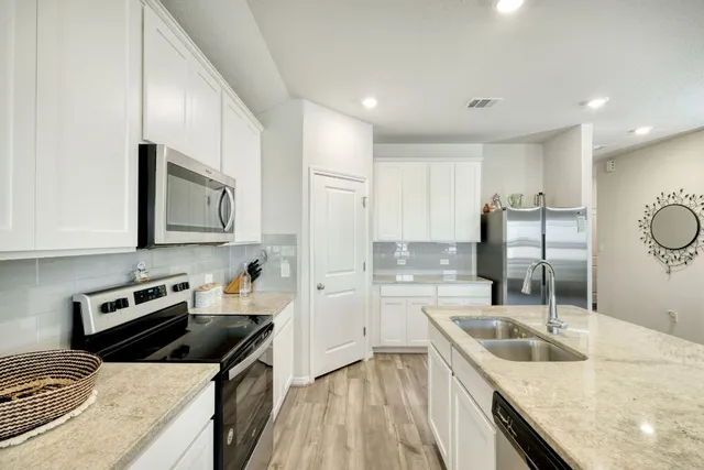 a kitchen that has a sink and a stove top oven