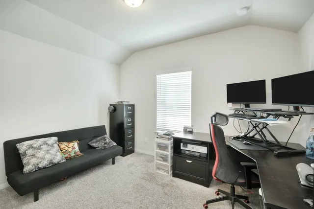 a view of a workspace with furniture and a window