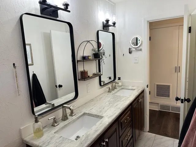 a bathroom with double vanity sink and a mirror