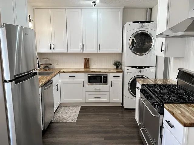 a kitchen with white cabinets and stainless steel appliances