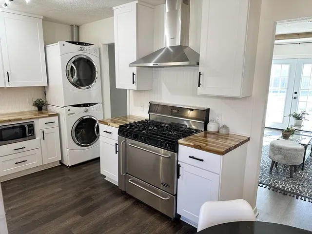 a kitchen with stainless steel appliances granite countertop a stove and a wooden floors