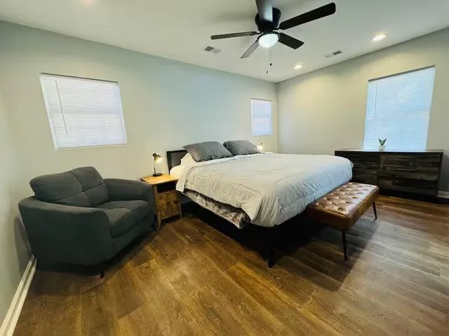 a spacious bedroom with a bed couch and window