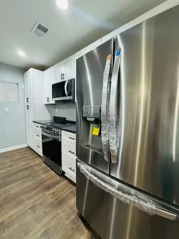 a kitchen with stainless steel appliances a refrigerator stove and microwave