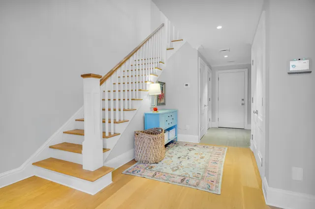 a kitchen with stainless steel appliances granite countertop a stove a sink a microwave a dining table and chairs with wooden floor