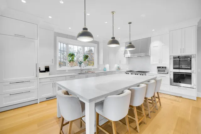 a kitchen with stainless steel appliances granite countertop a sink a stove and a large window