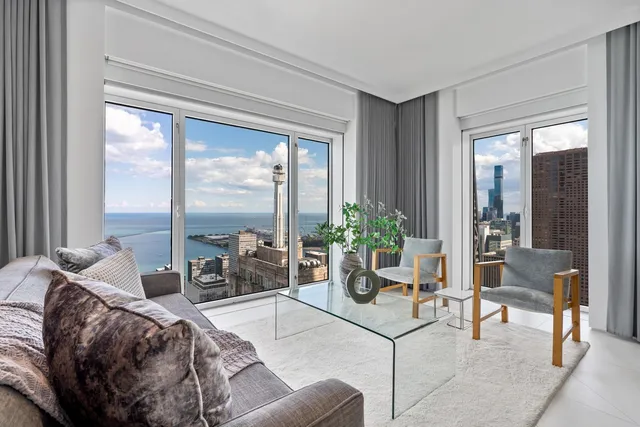 a living room with furniture a flat screen tv and a floor to ceiling window