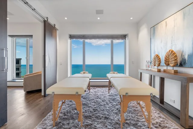 a spacious bedroom with a large bed and a chandelier