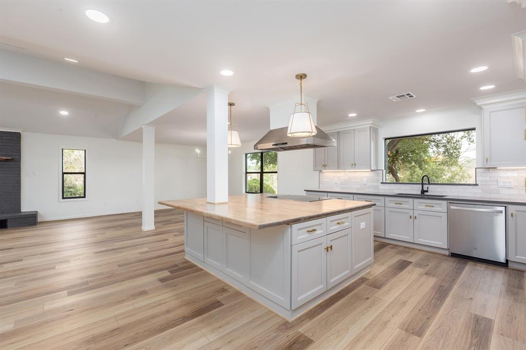 a kitchen with stainless steel appliances granite countertop wooden floors and white cabinets