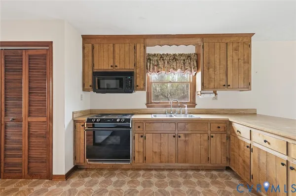 a kitchen with a stove sink and cabinets