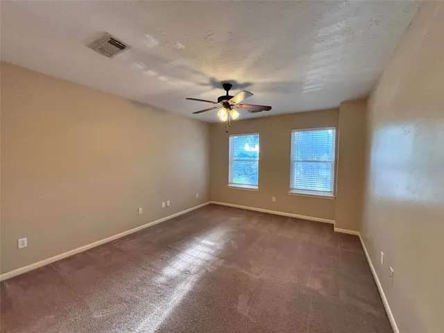 a view of a livingroom with a ceiling fan and window