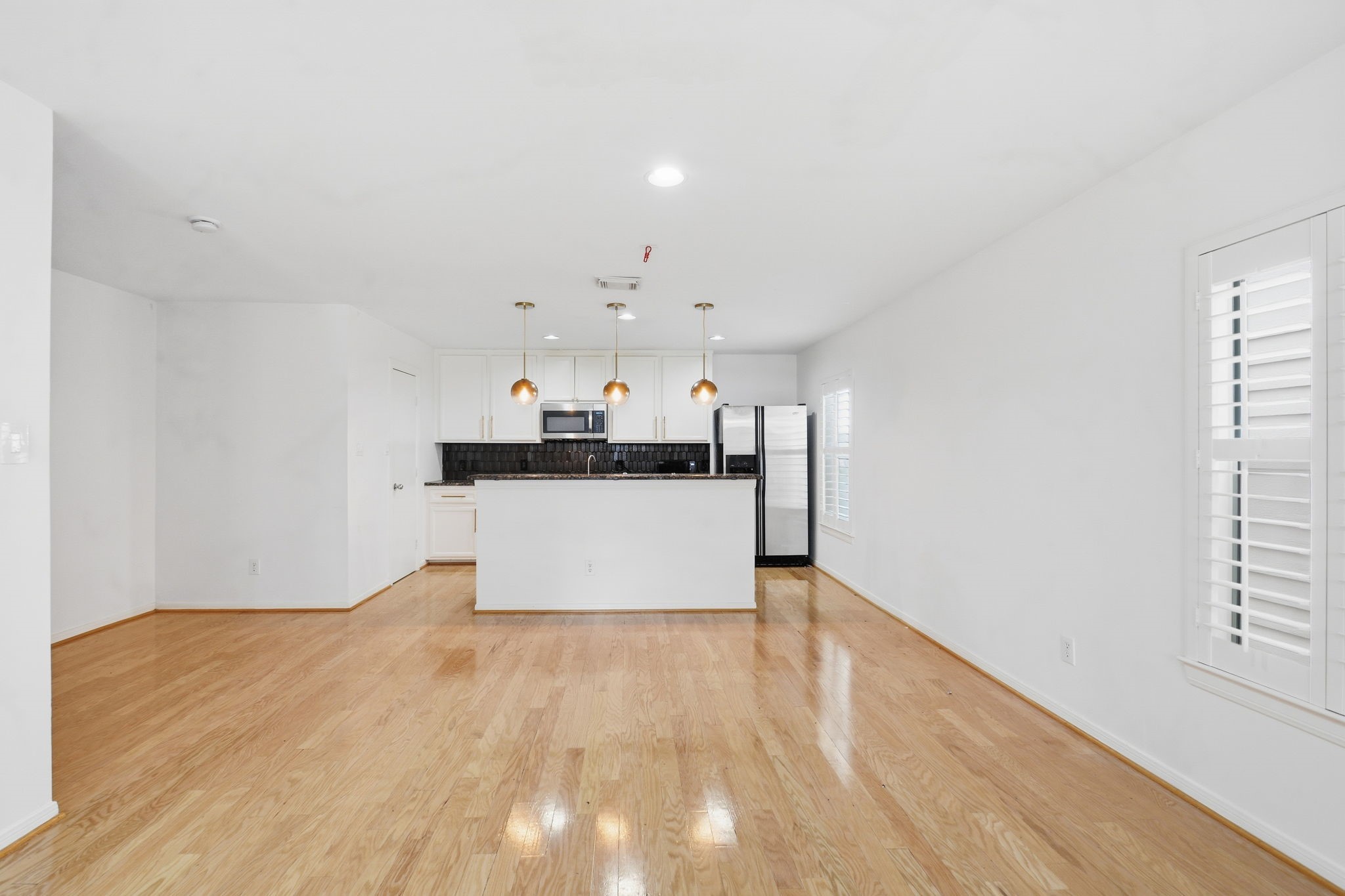 1714 West Webster Street Houston, TX 77019 - Photo 15 of 39 a living room with stainless steel appliances kitchen island a large counter top and a wooden floor