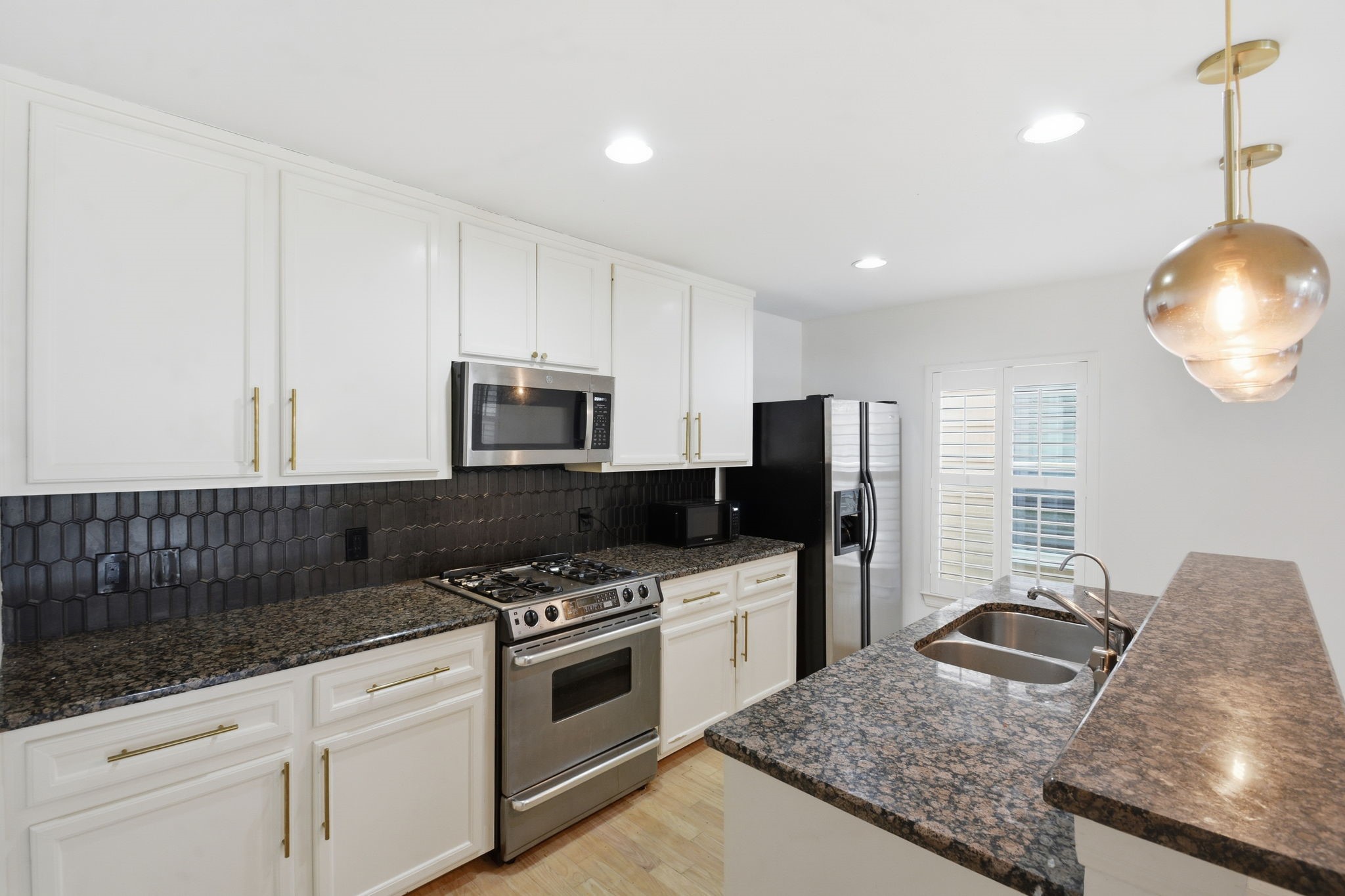1714 West Webster Street Houston, TX 77019 - Photo 22 of 39 a kitchen with stainless steel appliances granite countertop a stove a sink and a microwave