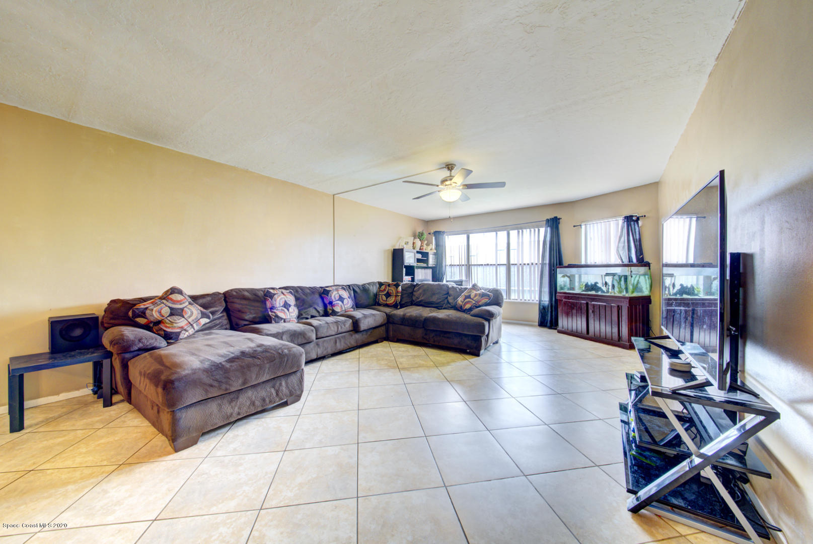 325 Tangle Run Boulevard, Unit 1125 Melbourne, FL 32940 - Photo 13 of 22 a living room with couches and kitchen view with wooden floor