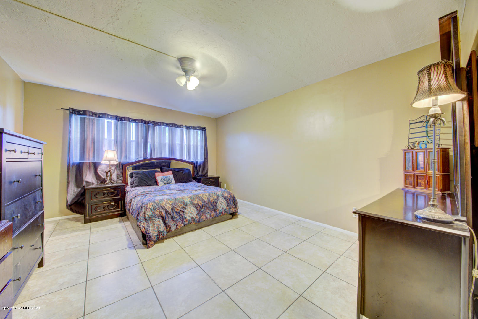 325 Tangle Run Boulevard, Unit 1125 Melbourne, FL 32940 - Photo 18 of 22 a bedroom with a bed and a flat tv screen on dresser