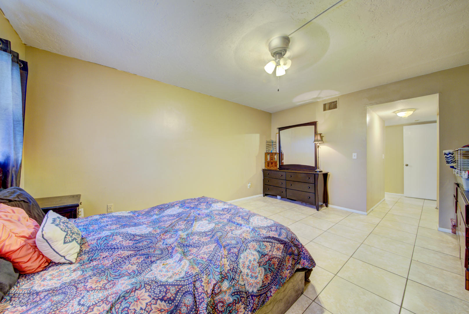 325 Tangle Run Boulevard, Unit 1125 Melbourne, FL 32940 - Photo 19 of 22 a bedroom with a bed and a chandelier