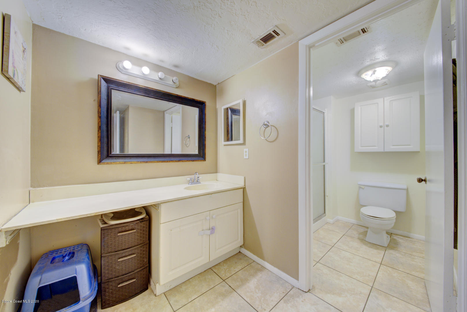 325 Tangle Run Boulevard, Unit 1125 Melbourne, FL 32940 - Photo 21 of 22 a bathroom with a toilet sink vanity and mirror