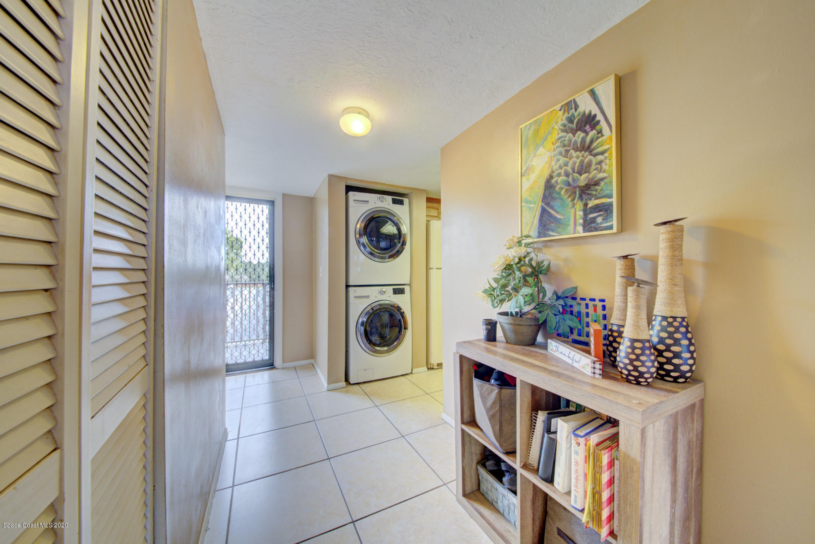 325 Tangle Run Boulevard, Unit 1125 Melbourne, FL 32940 - Photo 5 of 22 a view of a hallway with workspace and a potted plant