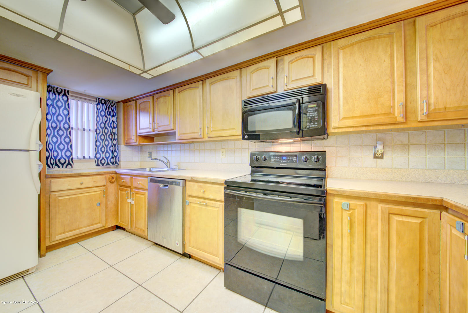 325 Tangle Run Boulevard, Unit 1125 Melbourne, FL 32940 - Photo 6 of 22 a kitchen with stainless steel appliances granite countertop a stove a sink and a microwave