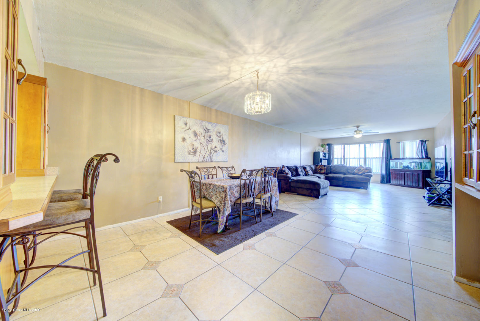 325 Tangle Run Boulevard, Unit 1125 Melbourne, FL 32940 - Photo 10 of 22 a living room with furniture and a chandelier