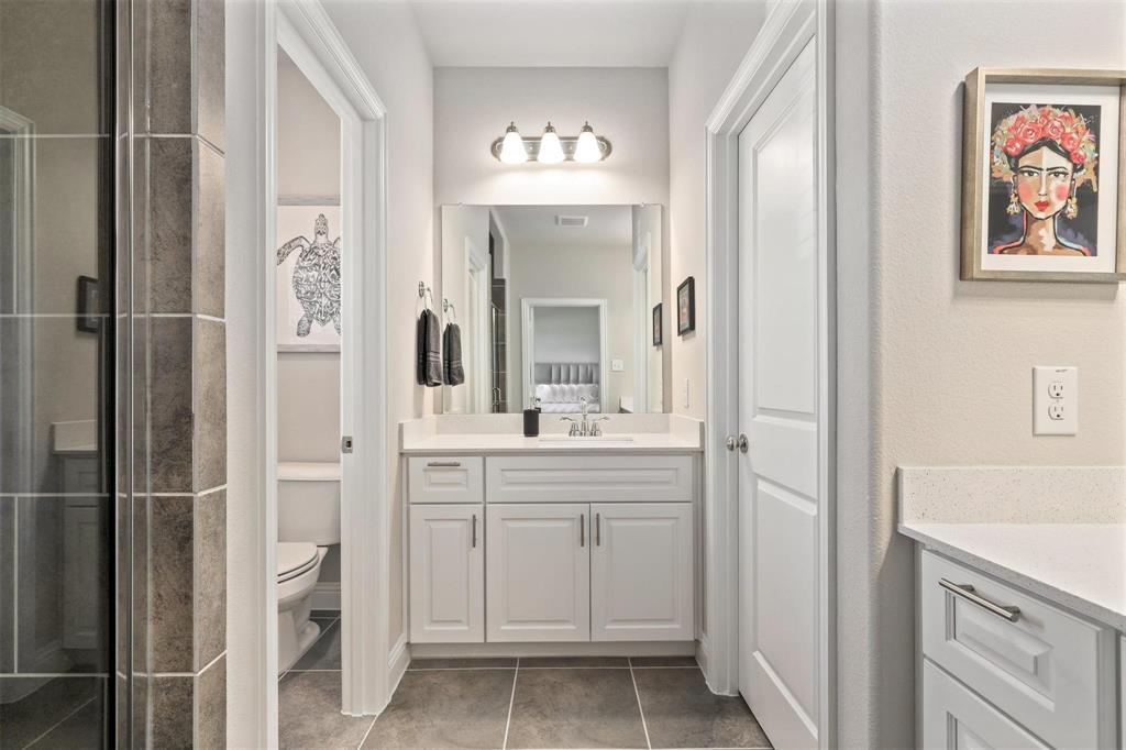 6246 Rilla Street Frisco, TX 75035 - Photo 15 of 26 a bathroom with a sink a mirror a vanity and a shower