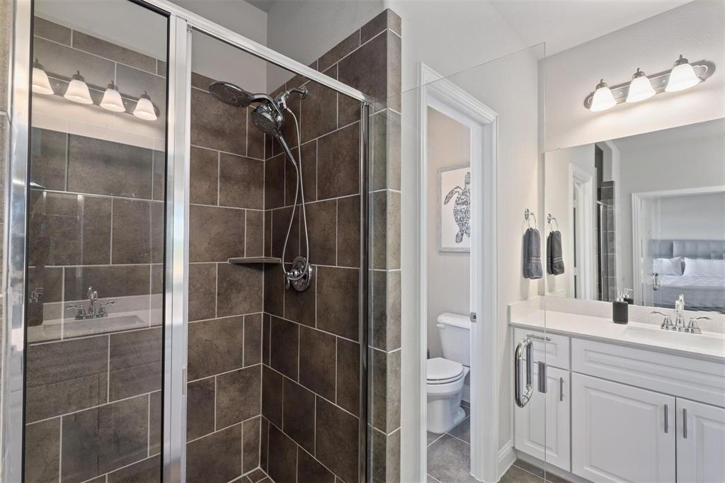 6246 Rilla Street Frisco, TX 75035 - Photo 19 of 26 a bathroom with a shower toilet sink and mirror