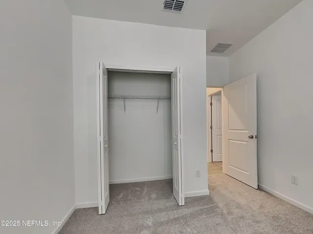 a view of an empty room and closet area