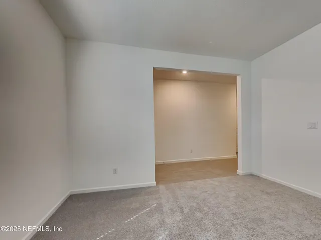 an empty room with wooden floor and garden view