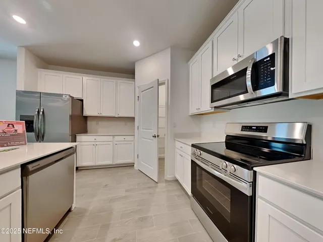 a kitchen with stainless steel appliances a refrigerator sink and microwave