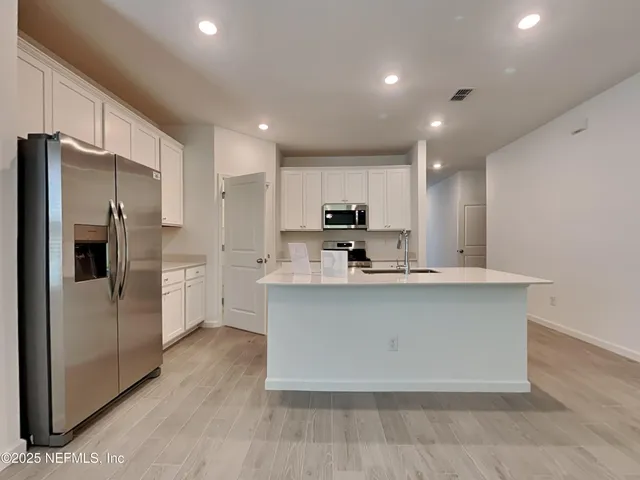 a view of a kitchen with a sink and a refrigerator