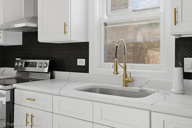 a kitchen with stainless steel appliances granite countertop a sink and cabinets