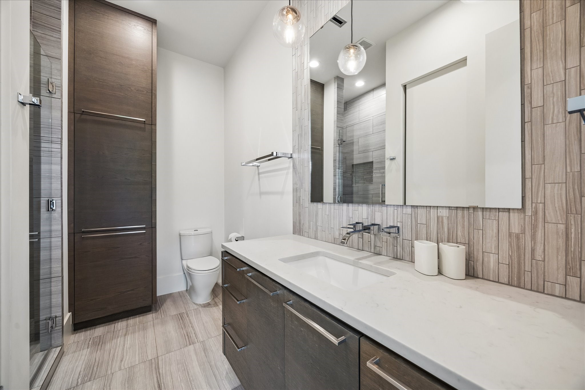 3814 Drake Street Houston, TX 77005 - Photo 34 of 50 This secondary bathroom is finished with a glass linear-drain shower, wide floating vanity, floor-to-ceiling designer tile and generous linen storage.