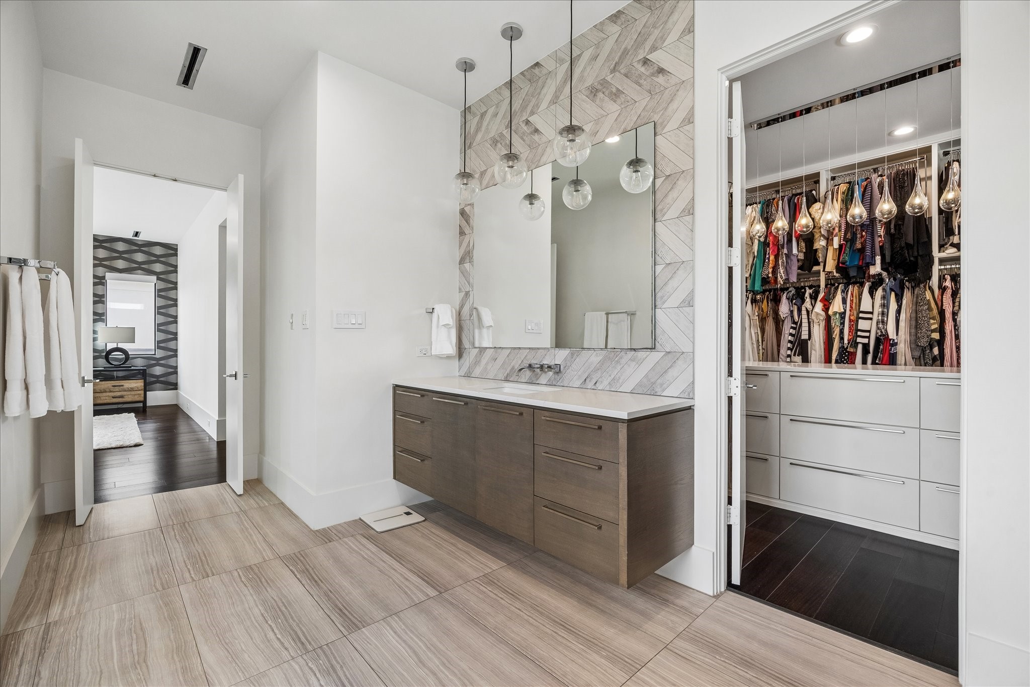 3814 Drake Street Houston, TX 77005 - Photo 43 of 50 The enviable primary walk-in closet impresses with custom cabinetry and shelving, hidden storage, a custom island, and direct access to the utility room.