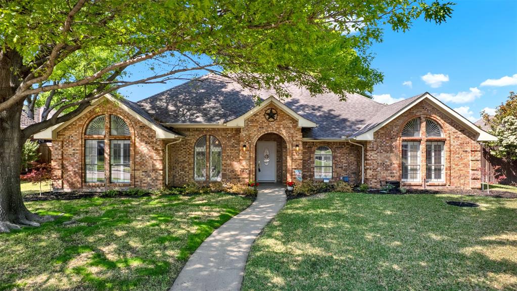 a front view of a house with a yard and trees