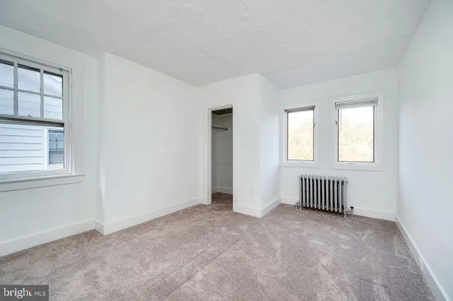 an empty room with windows and closet